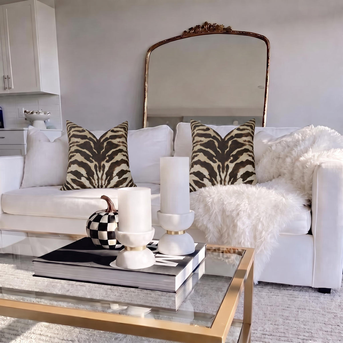 Two brown zebra print pillows styled on a white sofa